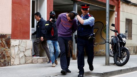 Un mosso custodia a uno de los detenidos por la desaparici�n de Janet Jumillas