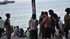 Cientos de personas migrantes reciben atenci�n sanitaria de profesionales del INGESA y voluntarios de Cruz Roja, en la playa del Trampol�n de Ceuta.
