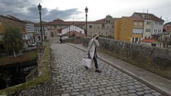 Una mujer con mascarilla camina por el puente viejo de Monforte durante el periodo de cierre perimetral del municipio