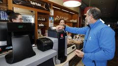 Un cliente pagando en el caj�n autom�tico de la Panificadora del Eo, en Foz