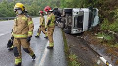 Los bomberos, junto al cami�n accidentado este martes en la bajada desde el alto de Gu�tara a Os Peares