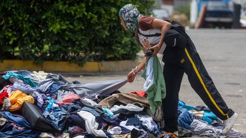 Una mujer busca ropa donada en uno de los campamentos instalados en La Guaira