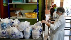 Voluntarios de la Cocina Econmica de Oviedo preparan bolsas con el men de comida y cena para entregar a las familias ms necesitadas que acuden a esta entidad