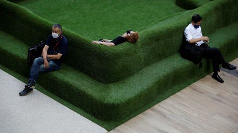 Personas que usan mscaras protectoras descansan en un banco en un edificio comercial, en Tokio, Japn