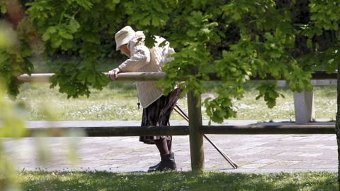 Una anciana pasea por un paseo fluvial