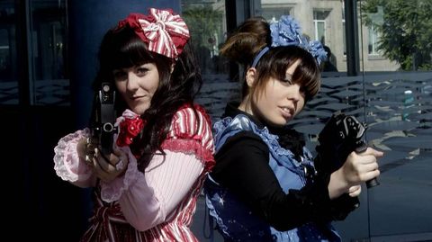 Dos lolitas, apuntando con armas de exposicin de la feria