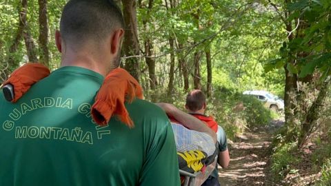 Agentes del Greim de la Guardia Civil llevan al herido en camilla