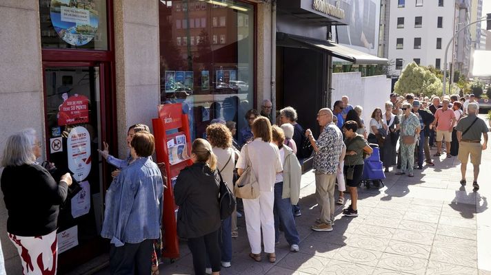 Personas haciendo cola ante una agencia para solicitar los viajes del Imserso.