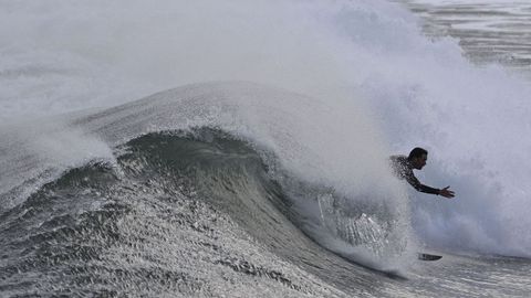 Una persona practica surf en la playa de San Lorenzo en Gij�n