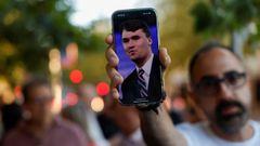 Un hombre sostiene su mvil con un retrato de Charlie Kirk.