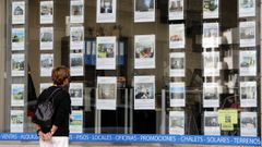 Foto de archivo de una mujer consultando los precios en el escaparate de una inmobiliaria de Vigo