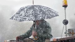 Un hombre se cubre de la nieve en Navia de Suarna, en Lugo