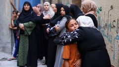 Una mujer consuela a una nia durante el funeral de cuatro adolescentes en Gaza