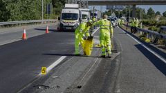 Dos operarios, retirando el martes los restos del accidente que dej� dos muertos en la A-6 en Lugo despu�s de que una furgoneta chocase contra un veh�culo de conservaci�n.
