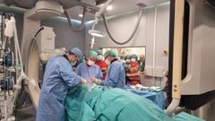 El equipo de Electrofisiolog�a del Chuac, implantando el nuevo desfibrilador Aurora. A la derecha, Enrique Ricoy con Javier Moya (centro), Ignacio Mosquera (izquierda) y Jaime Casares (detr�s, de rojo).