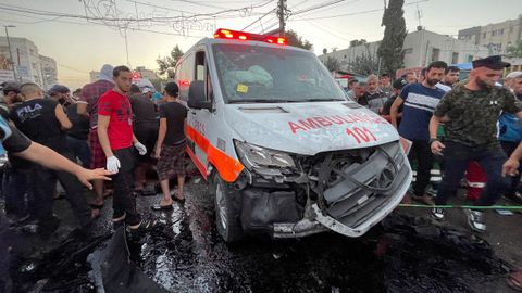 Un grupo de palestinos supervisa el estado de una ambulancia da�ada en las inmediaciones del Hospital de Shifa, en la Franja de Gaza.