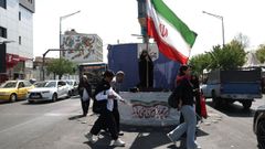 Una mujer sostiene una bandera de Ir�n en una calle de Teher�n