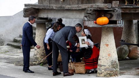 Los Reyes de Espaa saludan a unos vecinos de Moal que elaboran productos tpicos bajo un hrreo, durante su visita a la pedana asturiana galardonada este ao con el Premio Pueblo Ejemplar de Asturias