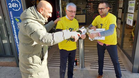 El alcalde de O Porri�o, Alejandro Lorenzo, sirve cava a los loteros Benjam�n y Andr�s Mart�nez, del X de la Suerte