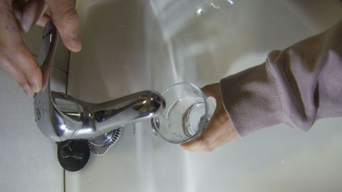 Una persona coge agua del grifo.