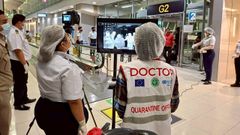 Las autoridades sanitarias aeroportuarias, con mascarillas protectoras, monitorean a los pasajeros de vuelos internacionales que llegan al aeropuerto de Bangkok tras la implementaci�n de medidas de control para los viajeros procedentes de la India. 