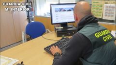 Un guardia civil examina en un ordenador los datos de una organizaci�n que estaf� 120.000 euros vendiendo productos falsos a trav�s de Internet