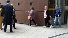  La madre condenada por quedarse con dinero de su hijo, con mascarilla rosa, a la salida de la Audiencia