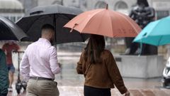 Viandantes con paraguas protegi�ndose de la lluvia en el centro de Oviedo