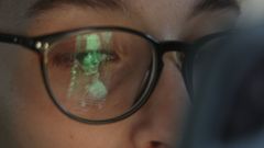 El reflejo de la pantalla de un m�vil en las gafas de una joven.
