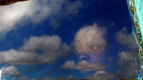 Un ni�o mira por la ventana de su caba�a al cementerio del expresidente sudafricano Nelson Mandela antes de su funeral