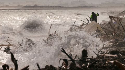 Búsqueda de víctimas en la playa del Saler, cerca de Valencia, donde se amontona basura arrastrada por la dana