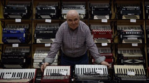 Antonio Fachado muestra algunos de los acordeones que tiene a la venta en su tienda