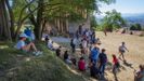 Grupos de turistas se protegen del calor en el exterior del monumento prerromnico de Santa Mara del Naranco