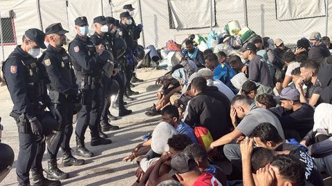 Agentes de la Polic&iacute;a Nacional trabajan en el traslado de cientos de inmigrantes que a&uacute;n duermen en la calle en Ceuta