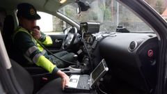 Un agente de la Guardia Civil, con un radar colocado en la AC-305 a su paso por Rianxo.