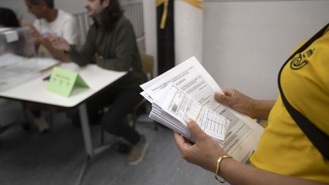 Una trabajadora de Correos lleva los votos por correo a una mesa electoral