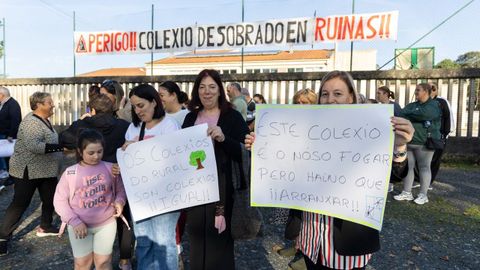 Varias madres con mensajes de protesta ante el colegio Virxe do Portal, en Sobrado.