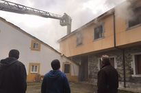 Los vecinos de la zona observando la situaci�n y los bomberos apagando el incendio. 