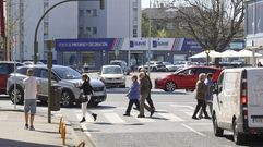 Tr�fico de veh�culos y peatones cruzando en un cruce de la avenida de Esteiro.