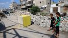 Dos ni�os miran a uno de los mojones que marcan la l�nea amarilla y que supuestamente mueven las tropas isral�es