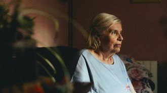 Una mujer mayor sentada en su casa