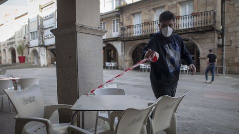 En el bar Tamara de Noia precintan mesas de la terraza para ajustarse al nuevo aforo disponible