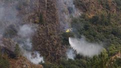 Un helicptero arroja agua el martes en la zona de Castro Dares (Quiroga) uno de los pocos lugares en los que este mircoles por la maana todava quedan focos activos en el incendio que afecta a este municipio y al de A Pobra do Brolln