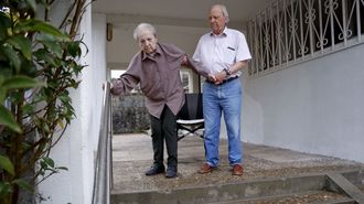 Emilio ayuda a su mujer, con alzhimer desde hace 12 aos, a bajar las escaleras apoyada en una barandilla 