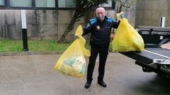 Un agente de la Policia Local de Carnota, en el momento de transportar material de protecci�n sobrante de la crisis del Prestige, y que fue donado al Hospital de Cee.