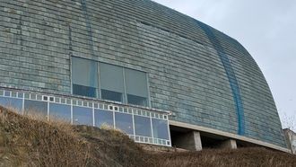 Fachada de la domus, con placas oxidadas y una red cubri�ndola para evitar desprendimientos