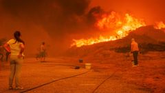 Varios vecinos intentan combatir las llamas en el incendio que asola Viseu y Guarda, en Portugal.