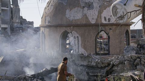 Un palestino recoge un Corn de las ruinas de un mezquita en la Franja.
