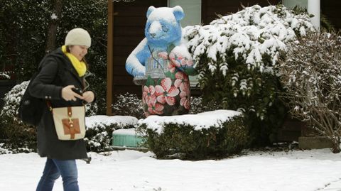 Una mujer pasea cerca de una escultura de cer�mica de un oso panda cubierto de nieve.