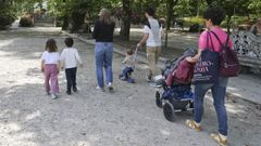 Una familia con cuatro ni&ntilde;os peque&ntilde;os pasea por el parque de la Alameda de Santiago.